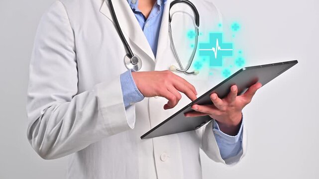 Young doctor scrolling on a digital tablet using a digital interface with a medical cross symbol and a white heartbeat icon