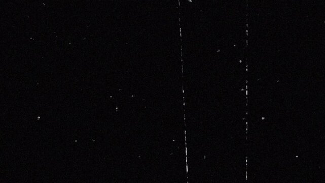 Grainy black film texture with scratches, noise, dust specks, and vintage monochromatic effect. Perfect for adding a retro touch to visuals.