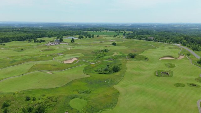 Drone video soaring above Paintbrush Golf Course at the Pulpit Club in Caledon, Ontario, reveals sculpted fairways, sand bunkers, lush greens, and winding paths on a sunny day.