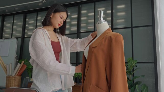 Asian woman designer using measuring tape measure cloth on clothing try-on stock