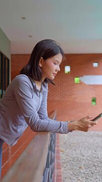 Asian sport woman using smartphone in building