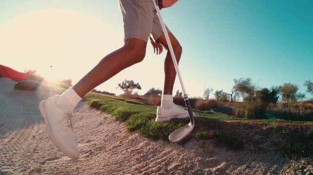 golfer hits bunker sand off cleats with wedge as he exits bunker in extreme slow motion, sand debris raining everywhere, sunset 4k 800fps wide shot push in