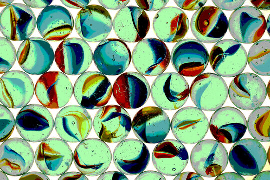 Glass marbles with colourful textures and patterns causing reflections and bubbles