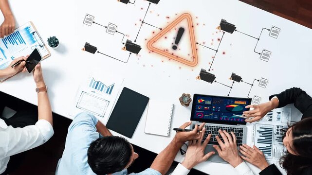 Collaborative Business Meeting on Data Analysis with Warning Alert Graphic and Charts Displayed on Laptop in Modern Office Setting Sigmoid