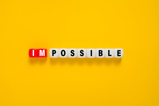 separate impossible words on cubes. motivation concept impossible becomes possible. isolated on yellow background