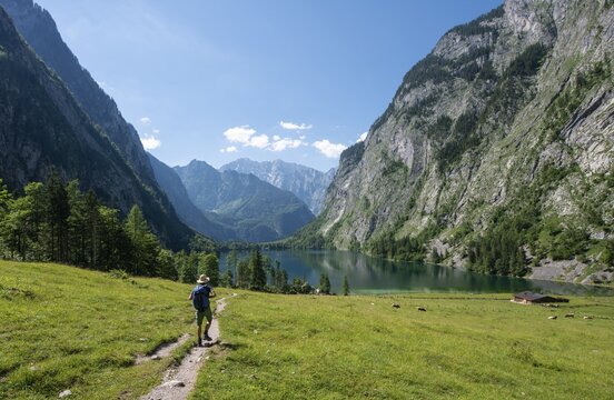 Hiker on the way to the lake Obersee, view over the Obersee, behind the Watzmann, Berchtesgaden National Park, Berchtesgaden Alps, Berchtesgadener Land, Bavaria, Germany