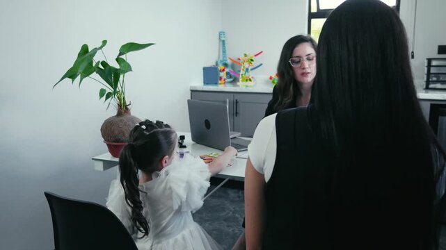Child psychologist engaging with young girl during therapy session
