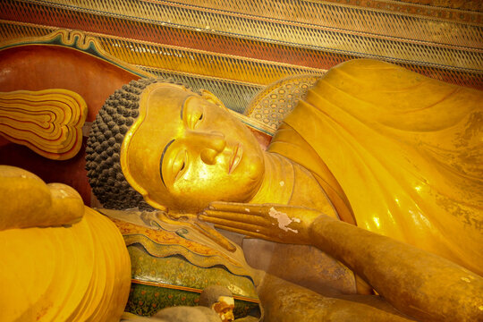 DIKWELLA, SRI LANKA - JULY 2026: Detail view of golden reclining Buddha statue face inside Wewurukannala Raja Maha Viharaya.