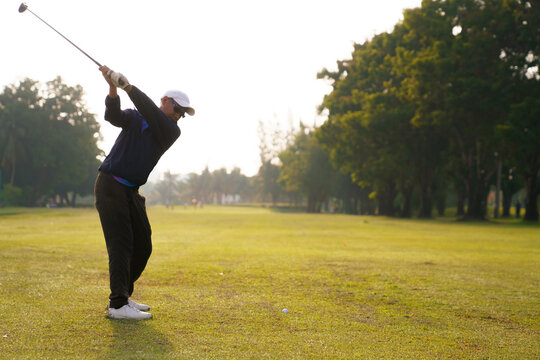 Golfer reaching top of backswing before downswing on fairway