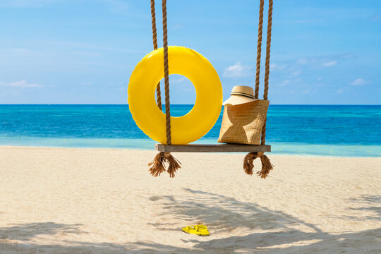 beach accessories lie on a rope swing overlooking the sea. beach holiday concept