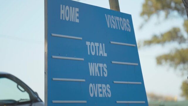 A cricket scoreboard at a local cricket field on an amateur cricket pitch or field.
