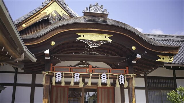 Traditional Japanese shrine architecture with ornate eaves and sacred paper decorations.
