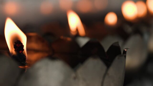 Close Up of Burning Oil Lamp Wick in Metal Lotus Holder