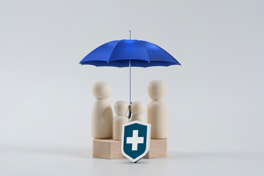 Family Health Insurance Protection Concept with Wooden Figures and Blue Umbrella
