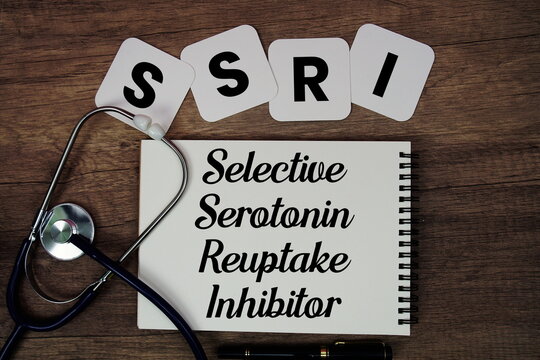 SSRI Selective Serotonin Reuptake Inhibitor text written on notepad with stethoscope on wooden background