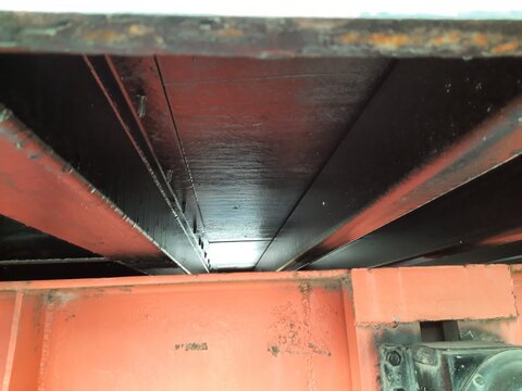 Close-up view of container underside and truck chassis frame connection