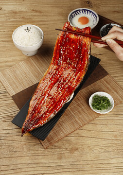Whole Japanese Kabayaki Grilled Eel Traditional Meal with Rice and Pickles on Wooden Table