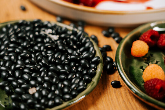 Black beans and raspberries on a wooden table