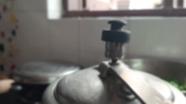 Close up of pressure cooker whistle releasing hot steam in kitchen