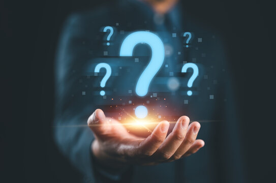 Businessman holding glowing question mark symbol representing problem solving uncertainty curiosity innovation decision making challenge and creative thinking concept in business and technology.