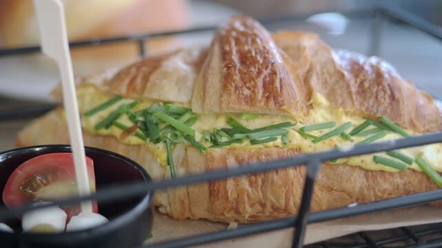 Egg and chive croissant served in a cafe setting