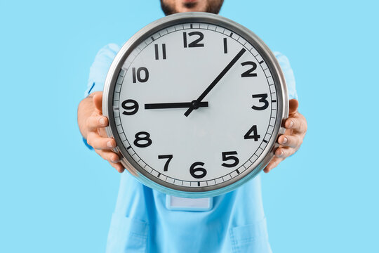 Healthcare professional holding a large wall clock, time management and scheduling in medical services