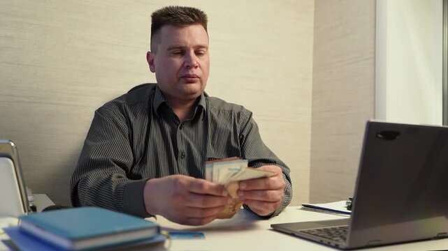 Businessman counting euro bills and putting them in pocket, deal with modest profit, neutral expression.