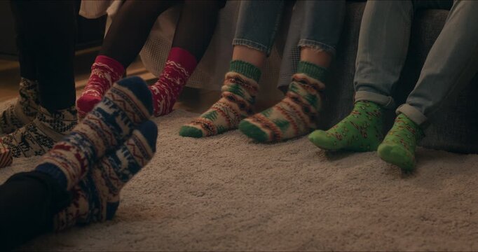 Description A: Close-up of a family standing together on a soft carpet wearing warm knitted Christmas socks in a cozy living room.