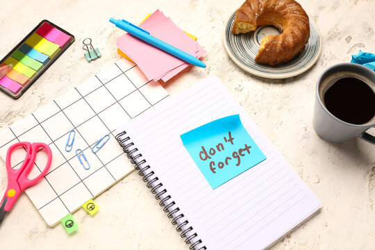 Sticky note with text DONT FORGET, stationery, coffee cup and croissant on grunge background