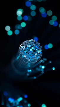 Macro view of blue fiber optic cable tip with bokeh lighting technology communication abstract connection internet transmission electronic telecommunication innovation