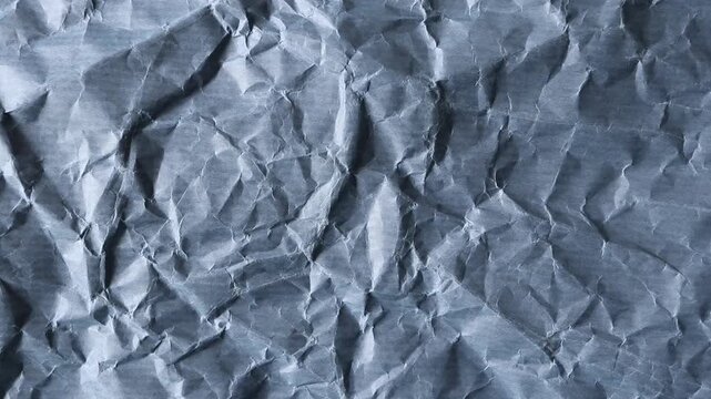 Static close-up video of dusty blue crumpled paper with faint horizontal stripes. Vintage grunge background with authentic creases for graphic design, overlays and creative projects.