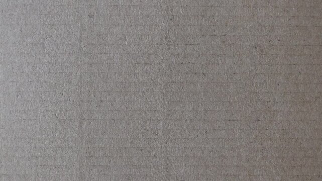 Static close-up video of brown cardboard with subtle horizontal stripes and pronounced paper fibers. Authentic grunge background for vintage, packaging and distressed design projects.