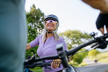 Obraz premium Active senior couple preparing for electric bike trip.