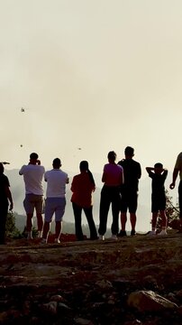 Local community members gathering outdoors to watch the intense sunset wildfire