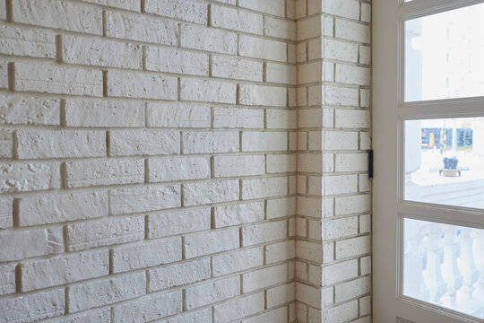White brick wall corner with window architectural detail