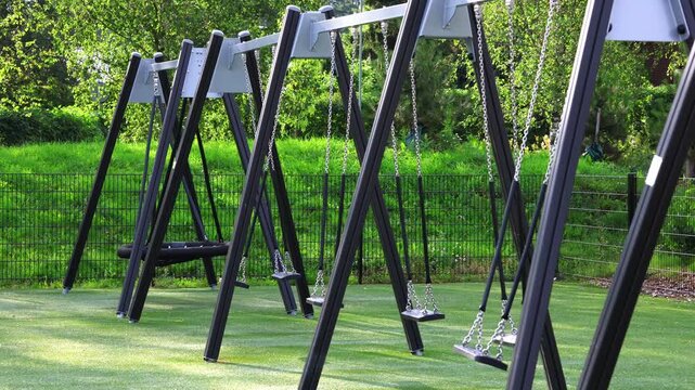 An abandoned school playground; the only swing set sways slowly in the wind. Slow-motion shot of the swing.