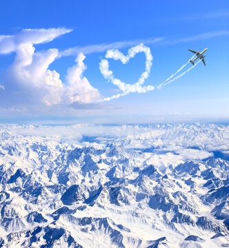 Airplane drawing heart in sky over the mountains. Jet flight route of aircraft in shape of heart. Heart-shaped flight path drawn by plane. Topic of holiday, travel, trip abroad on vacation, tour