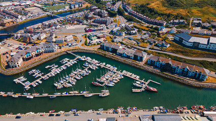 Aerial view of boat marina pontoons and residential waterfront buildings © Андрей Нелупов