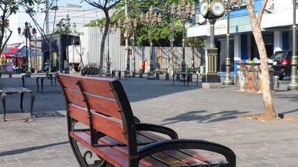 Urban city plaza with wooden benches and vintage street clock tower © Belva