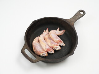 スキレットに入った手羽先の生肉 © Akio