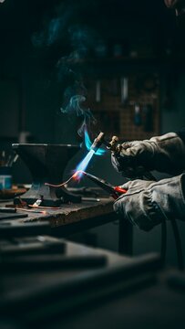 Expert Welder in Action with Torch and Metal in Workshop