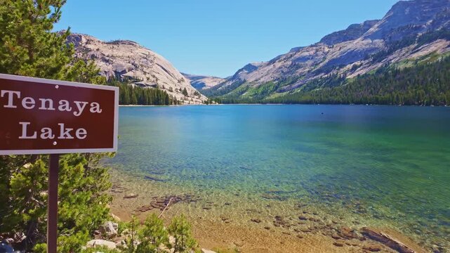 Scenic view of Tenaya Lake and an informational sign on a sunny day in Yosemite National Park, California