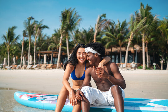 Interracial couple enjoying a romantic beach getaway, embracing love, laughter, and togetherness