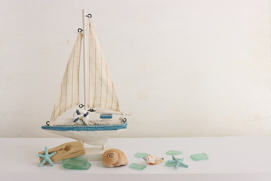 summer background with boat, blue sea glass and shells