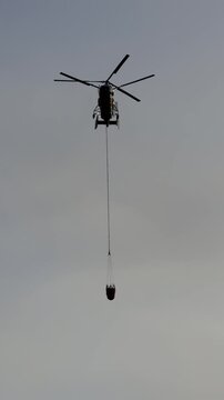 Firefighting helicopter flying through smoke