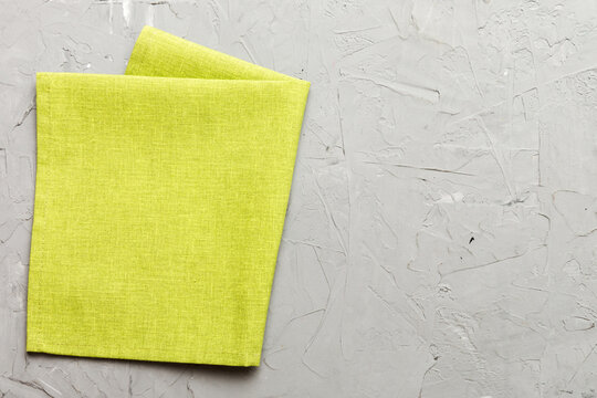 top view with green kitchen napkin isolated on table background. Folded cloth for mockup with copy space, Flat lay. Minimal style