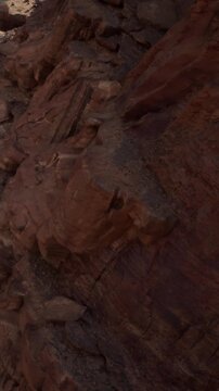 The scene shows various rocks arranged on the ground. Shadows fall across the rocks, highlighting their shapes. The light makes some areas harder to see.