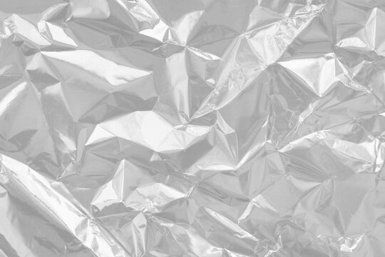 Shiny silver foil texture background, pattern of wrapping paper with crumpled and wavy.