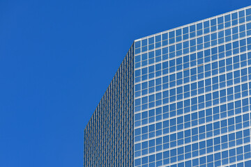 Fototapeta premium Modern glass office building corner with blue sky copy space