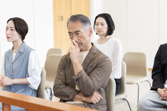 法廷の傍聴席で裁判を見守る真剣な傍聴人たち